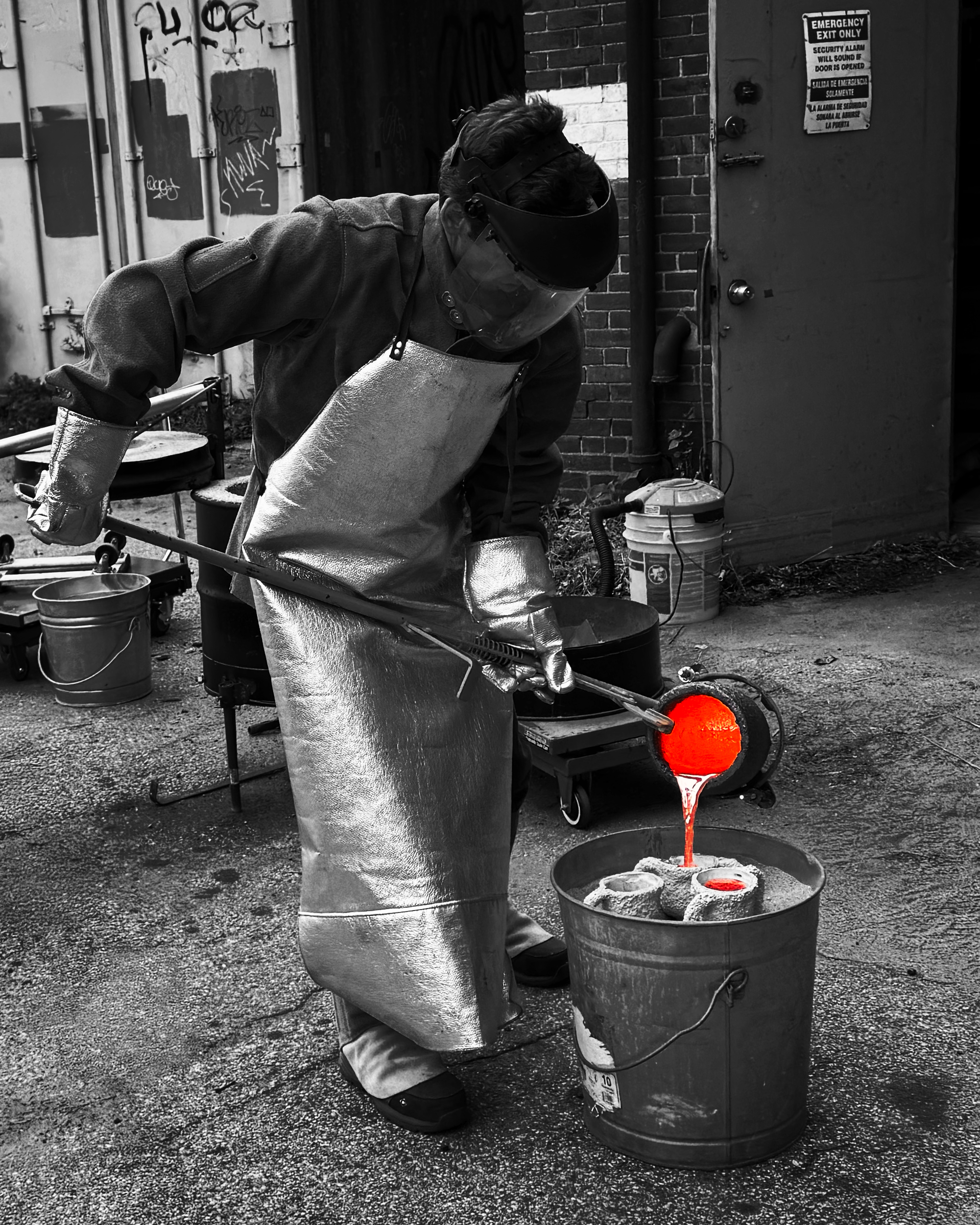Chris Kane, founder of Hot Funk Foundry, carefully pours glowing molten metal into molds, highlighting the intensity and precision of metal casting.