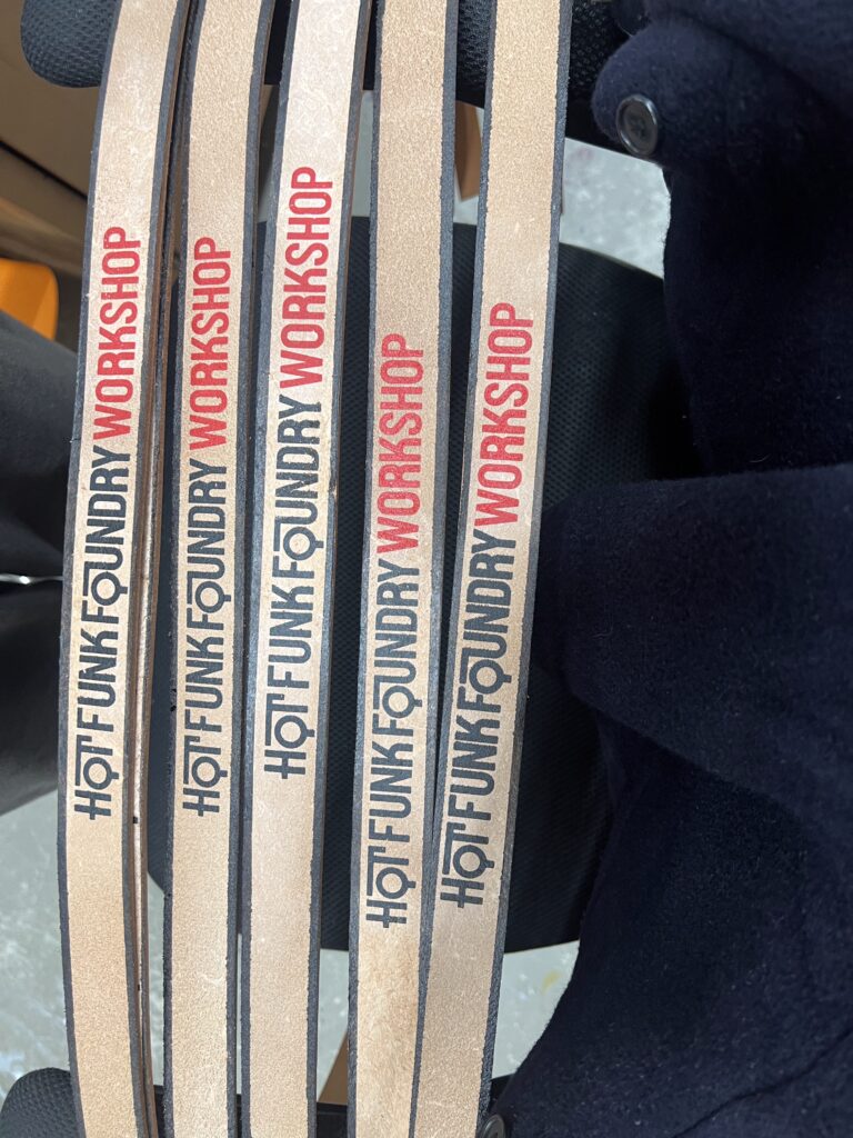 Four leather straps labeled "HOT FUNK FOUNDRY WORKSHOP" in black and red text.